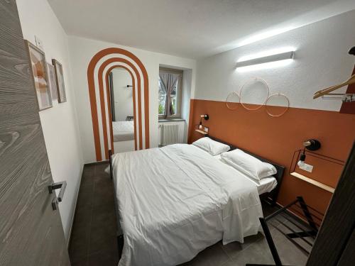 a bedroom with a large bed and a large mirror at Appartamenti relax Nus Spa in Nus