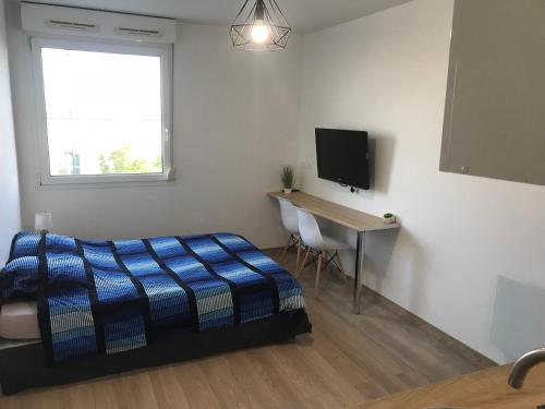 une chambre avec un lit, un bureau et une télévision dans l'établissement IKIZEN - Arena Confort - Boulingrin, à Reims