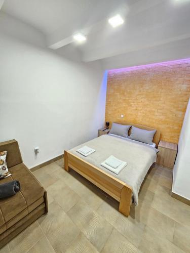 a bedroom with a large bed and a couch at Booking Apartments Alone 2 in Zemun