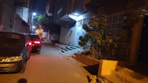 a car parked on the side of a street at night at Elegant Guest House Karachi in Karachi
