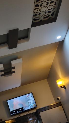 a room with a flat screen tv on the ceiling at Elegant Guest House Karachi in Karachi