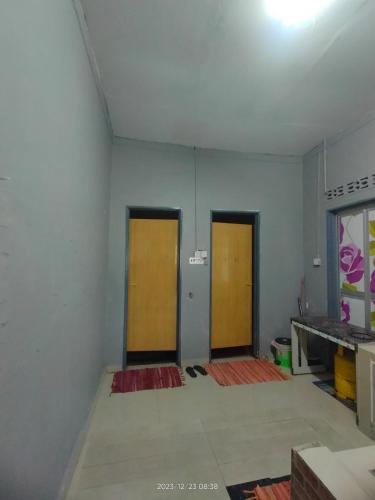 an empty room with two doors in the middle at Miezzan Homestay in Kuala Selangor