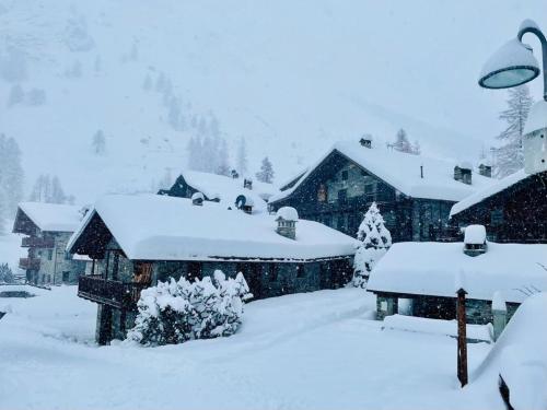 a yard covered in snow with a house at JARDIN DES ANGLAIS in Rhêmes-Notre-Dame