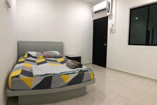 a bedroom with a bed with a colorful comforter at 4 Bedrooms Semi D Muslim Homestay by Mr Homestay Kulim in Kulim