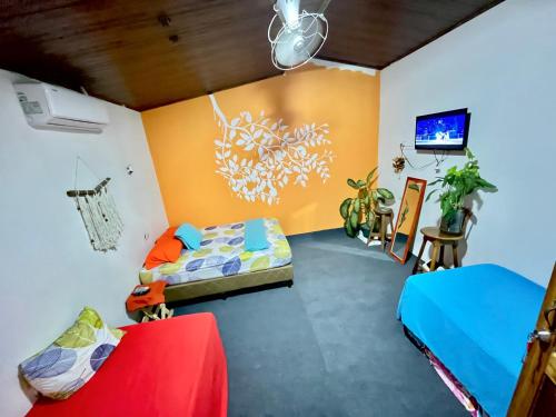 Zimmer mit 2 Betten und einem TV. in der Unterkunft Cheap Hostel Quepos in Quepos