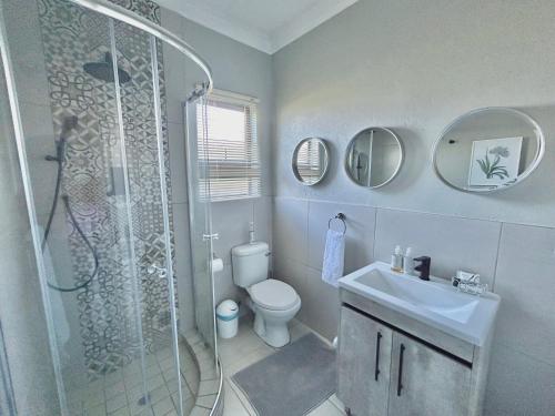 y baño con ducha, aseo y lavamanos. en The Acorn @ Skyfall Country Estate, en Polokwane