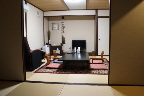a view of a living room with a table and chairs at Yufuin-Sanso Waremokou in Yufuin