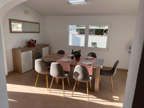 a dining room with a wooden table and chairs at Villa OM, Piscina Privada, Aire Acondicionado Free in L'Escala