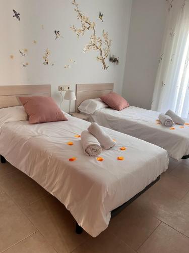 two beds with towels and orange slices on them at Villa OM, Piscina Privada, Aire Acondicionado Free in L'Escala