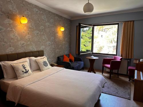 ギレスンにあるLonca Butik Hotelのベッドとリビングルームが備わるホテルルームです。