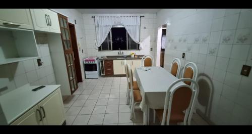 a kitchen with a table and chairs in a room at VS HOSPEDAGEM APARTAMENTO 2 in Cascavel