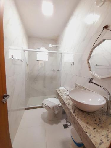 a white bathroom with a sink and a shower at Estrela Azul Guest House Búzios in Búzios