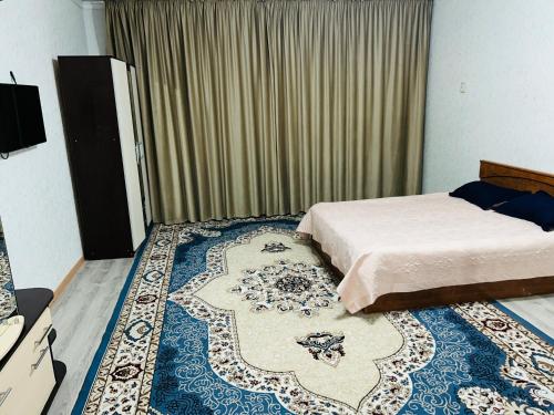 a bedroom with a bed and a large rug at Квартира в центре города,в ЖК Куралай in Qyzylorda