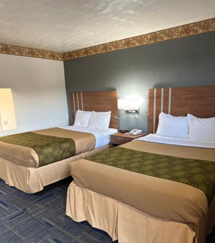 Un pat sau paturi într-o cameră la Budget Host Inn Charleston
