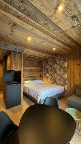 a bedroom with a bed and a table and chairs at Résidence GRAND COCOR, Skis aux pieds -Studio 25 m2- by MONTBLANC LOGDE in Val dʼIsère
