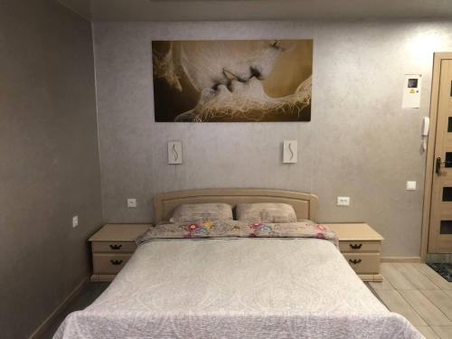 a bedroom with a bed and a painting on the wall at Apartments Апартамент Рабочая 81, Кирова Kirova in Dnipro
