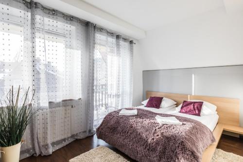sypialnia z łóżkiem i dużym oknem w obiekcie Apartament Levante w Zakopanem