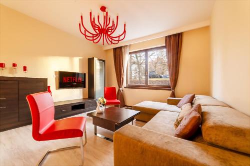 a living room with a couch and a chandelier at Imperial Apartment in Bohemia Residence by Rentez in Karlovy Vary