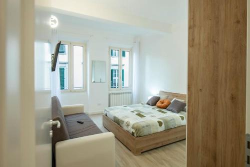 フィレンツェにあるMamo Florence - Verdi Apartmentのベッドルーム1室(ベッド1台、椅子、窓付)