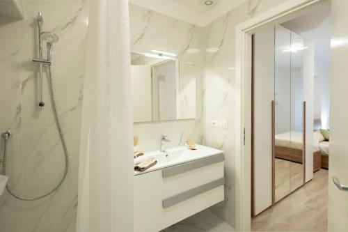 フィレンツェにあるMamo Florence - Verdi Apartmentの白いバスルーム(シンク、シャワー付)