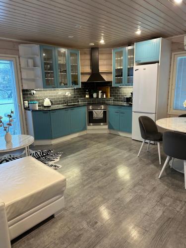 uma cozinha com armários azuis e um frigorífico branco em Villa Lilla em Porvoo