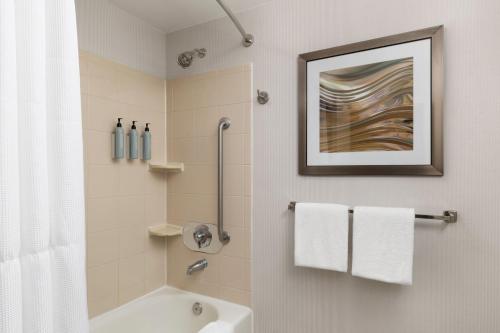 a bathroom with a white tub and a shower with a picture at Courtyard Wall at Monmouth Shores Corporate Park in Wall Township