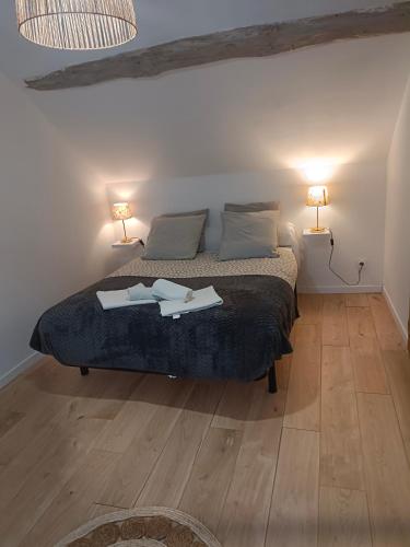 une chambre avec un lit avec deux lampes dessus dans l'établissement La Maison de Juliette maison entière avec garage et terrain, à Condé-sur-Sarthe