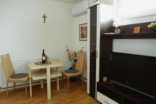 sala de estar con mesa, sillas y TV en Soba Luić, en Županja