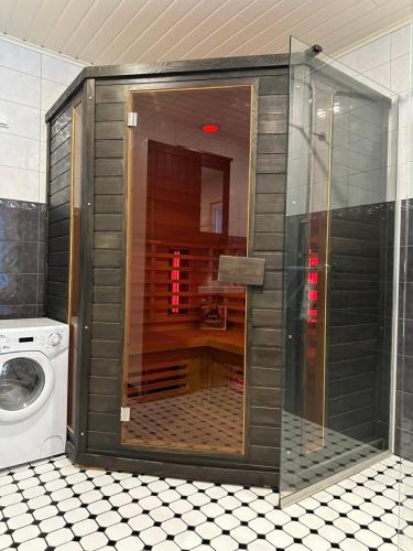 a glass shower in a bathroom with a washing machine at Villa Lilla in Porvoo