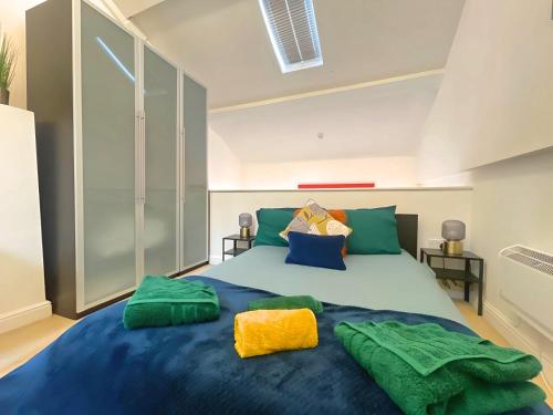 a bedroom with a large blue bed with green pillows at Vibrant Loft Apartment in Grade II Listed Georgian Building in Sheffield