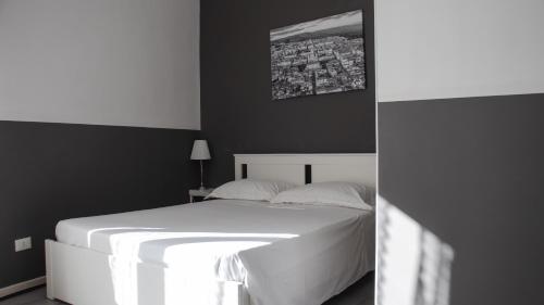 a bedroom with a white bed and a black wall at DUCEZIO rooms in Noto