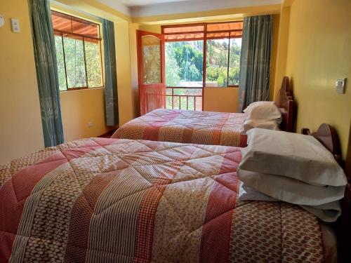 a bedroom with two beds and a window at Fundo San Silvestre in Huaraz