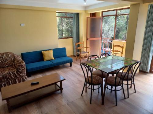 salon z niebieską kanapą i stołem w obiekcie Fundo San Silvestre w mieście Huaraz
