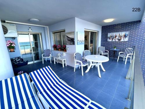 卡爾佩的住宿－TIMORA SEA VIEW New Apart' Hipocampos，配有桌椅、桌子和桌椅的房间