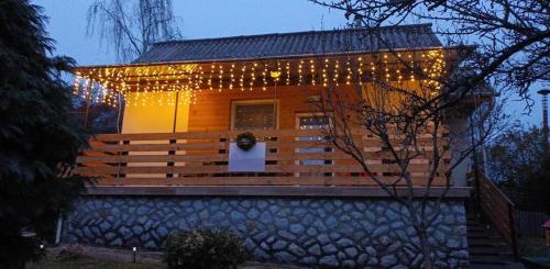 une petite maison avec des lumières de Noël. dans l'établissement Lianne Apartman, à Miskolctapolca