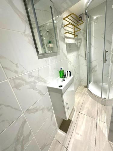 a white bathroom with a sink and a shower at Kent House Suites - SE26 in Forest Hill