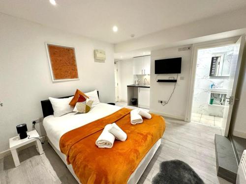 a bedroom with a large bed with towels on it at Kent House Suites - SE26 in Forest Hill