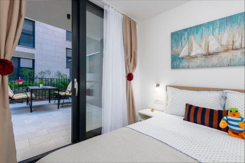 ein Schlafzimmer mit einem Bett und einem Balkon in der Unterkunft Lupo Gravosa FREE PARKING in Dubrovnik