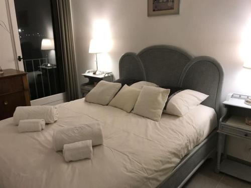 uma grande cama branca com almofadas brancas em Espace Sainte-Maxime em Sainte-Maxime