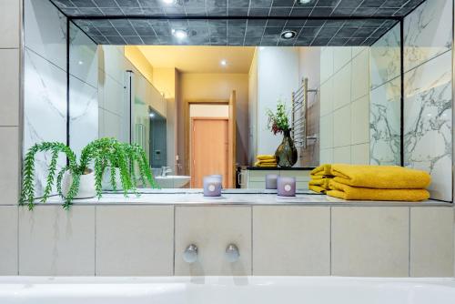 a bathroom with a large mirror and a sink at Welcome London Piccadilly Circus in London