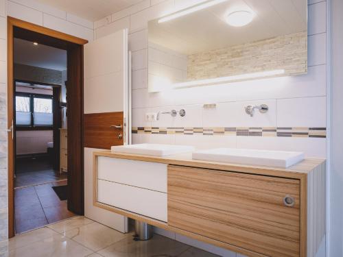 a bathroom with two sinks and a mirror at Appartements Enzian by we rent in Rauris