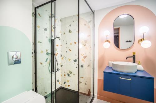 ein Bad mit einer Dusche und einem Waschbecken in der Unterkunft Pink Studio przy Rynku Parking-Kościuszki in Breslau