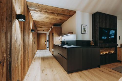 a kitchen with black counters and a wooden ceiling at Balma Restaurant Apart in Lech am Arlberg