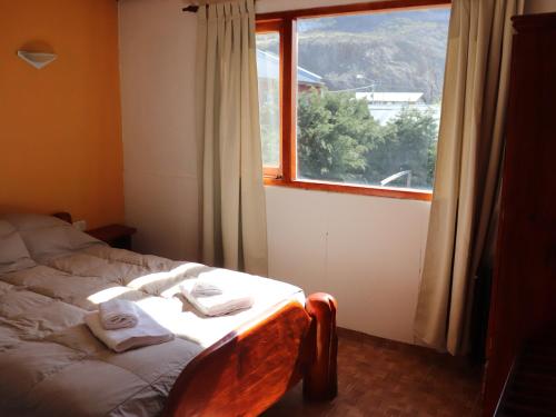 a bedroom with a bed in front of a window at Kalenshen in El Chalten