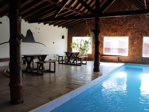 a pool in a house with tables and a swimming pool at Kalenshen in El Chalten