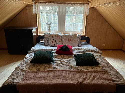 uma cama grande com almofadas num quarto em Gaj-Raj em Łąkorz