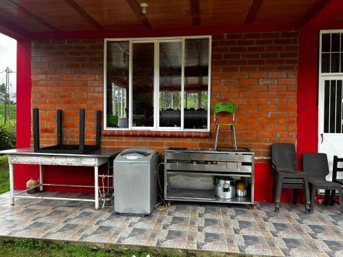 聖羅莎德卡瓦爾的住宿－finca en guacas，一个带红色房子的庭院内的烧烤架