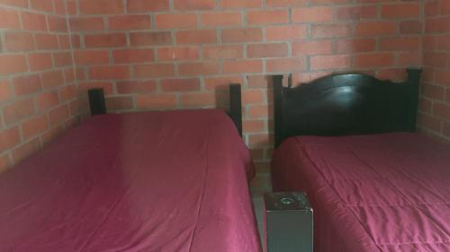 聖羅莎德卡瓦爾的住宿－finca en guacas，砖墙客房的两张床