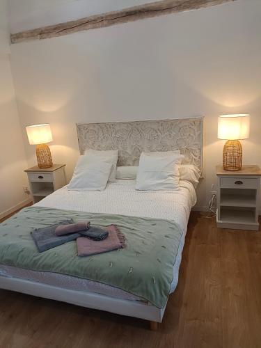 a bedroom with a bed with two lamps and towels on it at La Maison de Juliette maison entière avec garage et terrain in Condé-sur-Sarthe