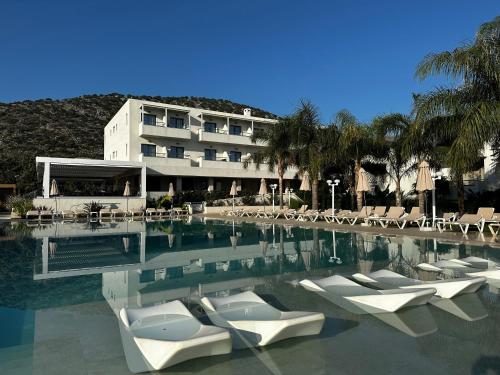 una piscina con sedie a sdraio e un edificio di Kyknos Beach Hotel & Bungalows a Mália